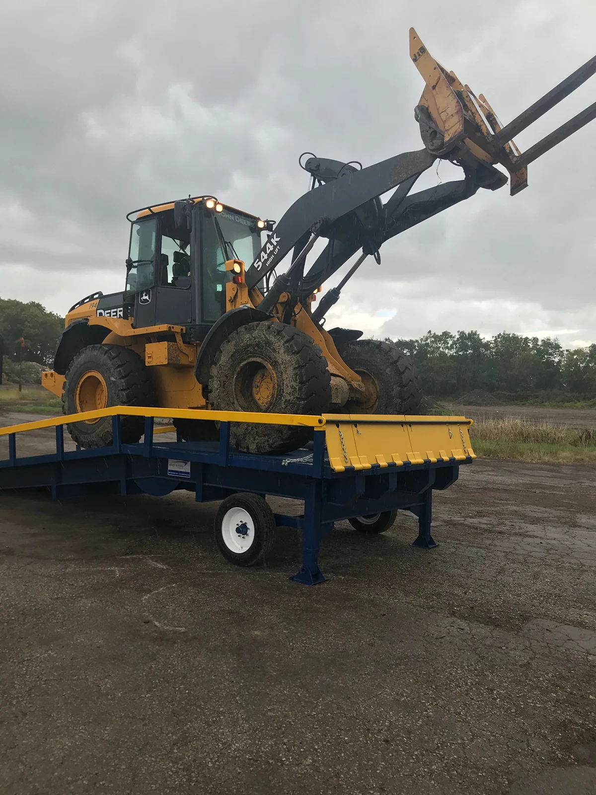 construction loader onto of an Adapt-A-Ramp heavy duty yard ramp